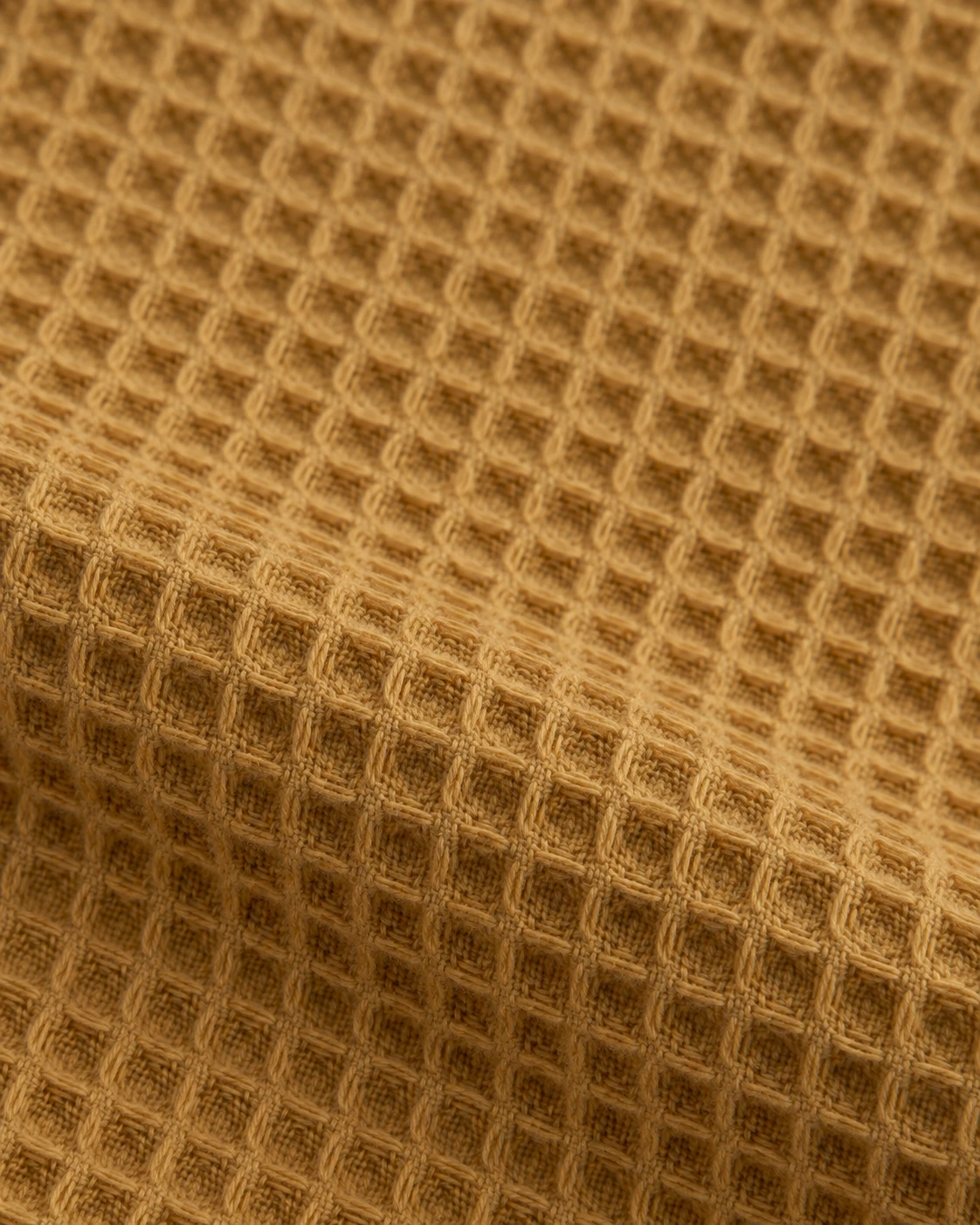 Ochre cotton waffle with small shallow cells, closed woven centres and fine interlaced yarns